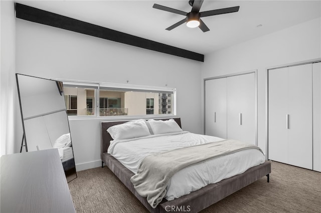 bedroom with beamed ceiling, multiple closets, carpet floors, and a ceiling fan