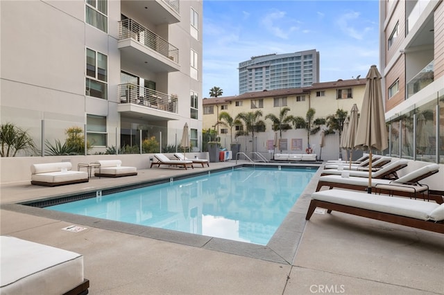 community pool featuring a patio area, an outdoor living space, and fence