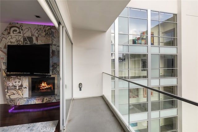 balcony featuring a glass covered fireplace