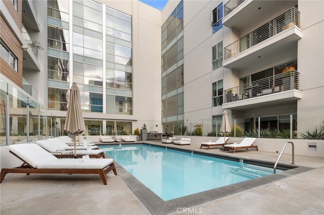 community pool with a patio area and outdoor lounge area