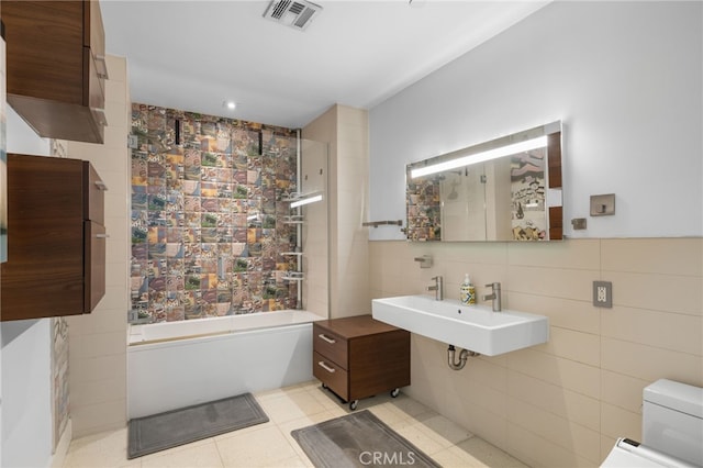 bathroom featuring a sink, toilet, tile walls, and backsplash