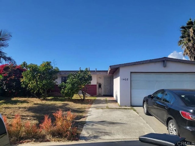 single story home featuring stucco siding, an attached garage, and concrete driveway