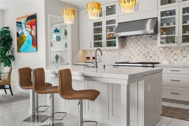 244 Coal Mine, Irvine, CA 92602 - bar area with wall chimney range hood, a chandelier, tasteful backsplash, pendant lighting, and light marble finish floors