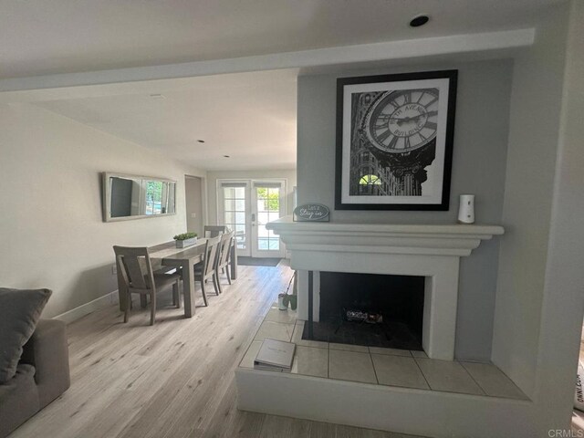 dining space with wood finished floors, a fireplace, and baseboards