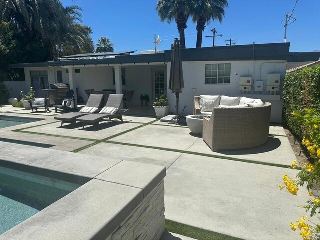back of house featuring a patio, outdoor lounge area, an outdoor pool, and stucco siding