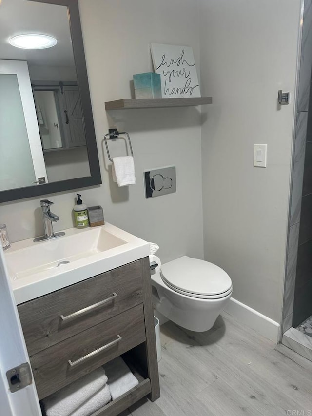 full bath featuring vanity, toilet, wood finished floors, and baseboards