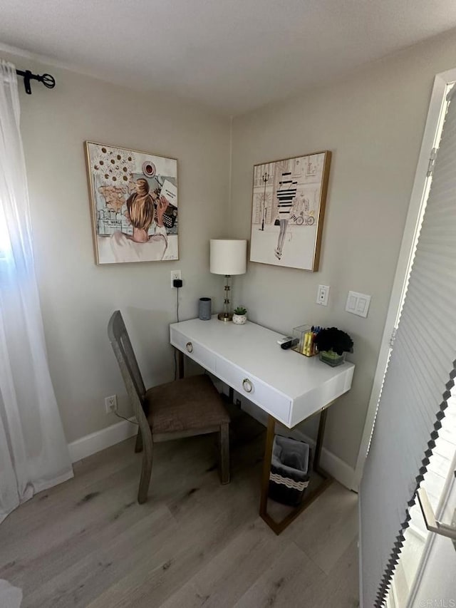office area featuring light wood-style floors and baseboards
