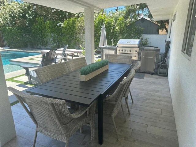 view of patio / terrace featuring grilling area, outdoor dining space, and an outdoor kitchen