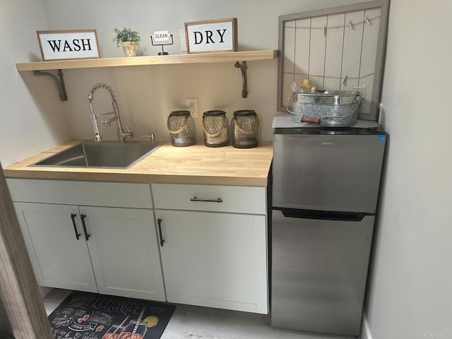 indoor wet bar featuring freestanding refrigerator
