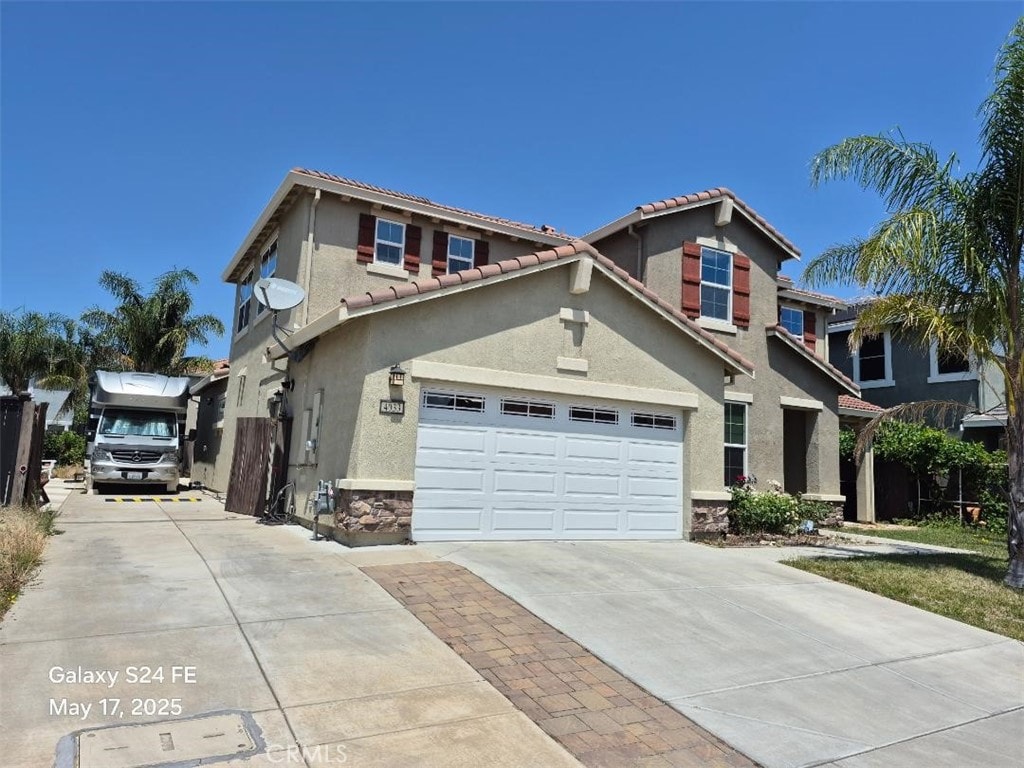4033 Morrison Way, Roseville, CA 95747 - view of front of property with concrete driveway, stone siding, stucco siding, a tiled roof, and a garage