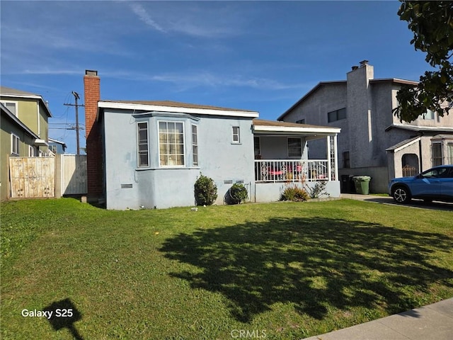 view of front of house featuring a porch, stucco siding, and a chimney