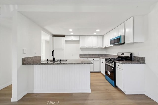 383 N Melrose Dr Unit G, Vista, CA 92083 - kitchen featuring appliances with stainless steel finishes, a sink, a peninsula, dark stone countertops, and white cabinets