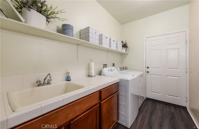 laundry area featuring independent washer and dryer, dark wood-style floors, and cabinet space