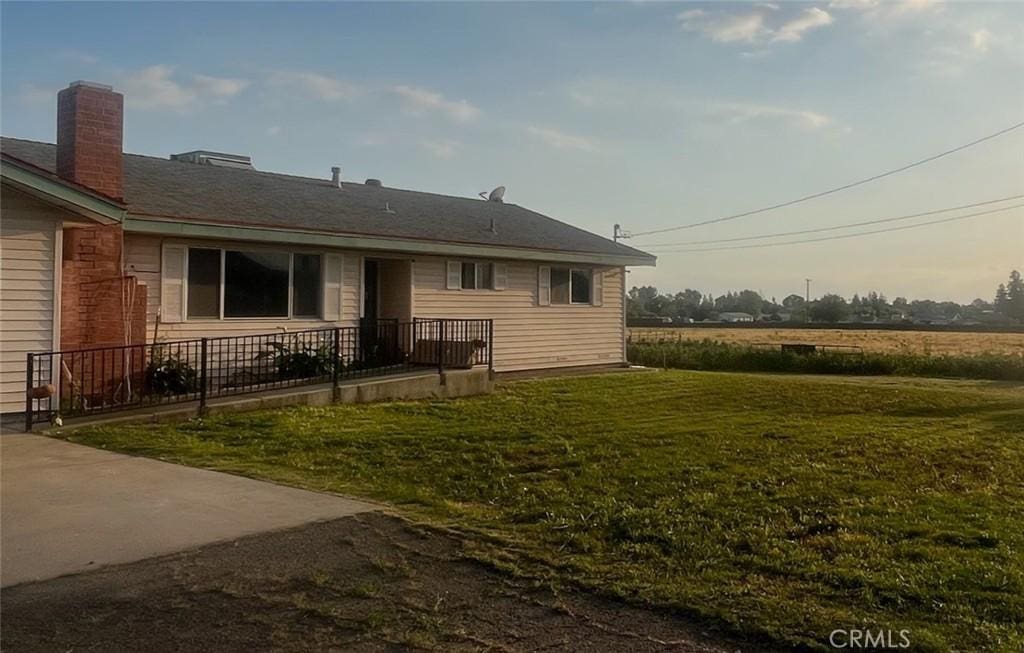 679 E Mulberry Ave, Porterville, CA 93257 - rear view of property with a yard and a chimney