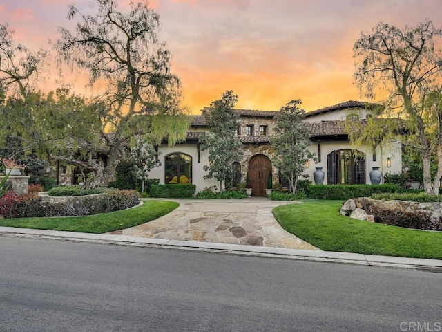 18414 Calle La Serra, Rancho Santa Fe, CA 92091 - mediterranean / spanish-style home with curved driveway, stucco siding, and a yard