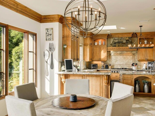 18414 Calle La Serra, Rancho Santa Fe, CA 92091 - kitchen featuring a chandelier, decorative backsplash, light stone countertops, glass insert cabinets, and a sink