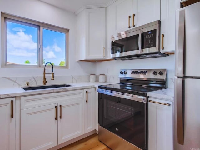 1025 Plover Way, Oceanside, CA 92057 - kitchen with appliances with stainless steel finishes, a sink, white cabinetry, and light stone countertops