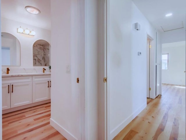 1025 Plover Way, Oceanside, CA 92057 - hall with light wood-type flooring, a sink, and baseboards