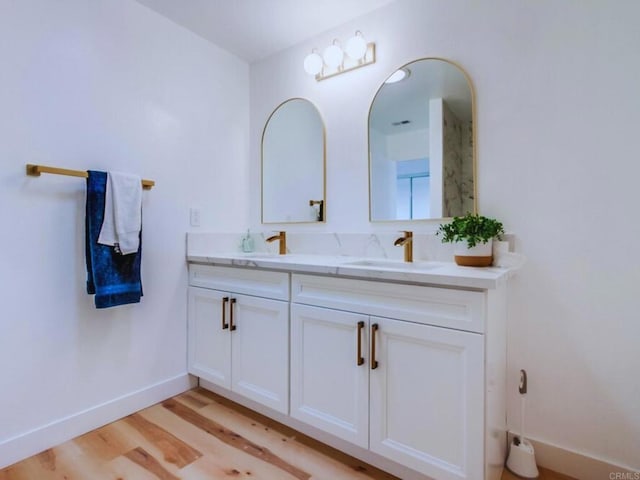 1025 Plover Way, Oceanside, CA 92057 - full bathroom featuring double vanity, wood finished floors, and baseboards