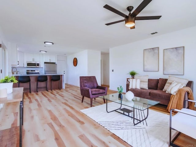 1025 Plover Way, Oceanside, CA 92057 - living area featuring a ceiling fan, light wood finished floors, and baseboards