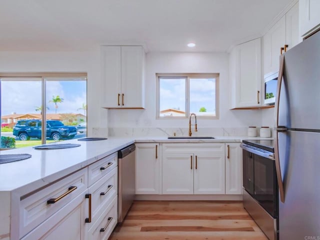 1025 Plover Way, Oceanside, CA 92057 - kitchen with appliances with stainless steel finishes, a sink, white cabinetry, recessed lighting, and light wood-style floors