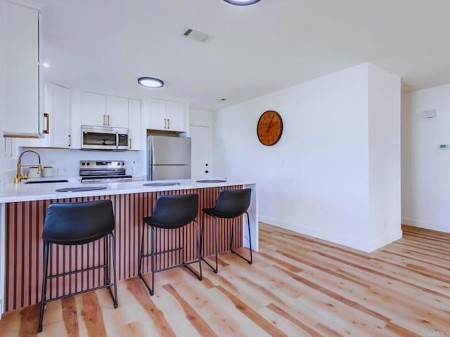 1025 Plover Way, Oceanside, CA 92057 - kitchen with appliances with stainless steel finishes, a sink, light wood-style flooring, and light countertops
