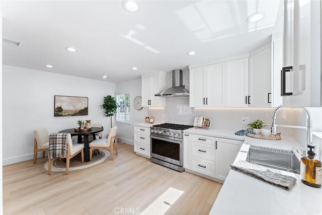 18011 Theodora Dr, Tustin, CA 92780 - kitchen with wall chimney exhaust hood, high end stove, light countertops, recessed lighting, and a sink
