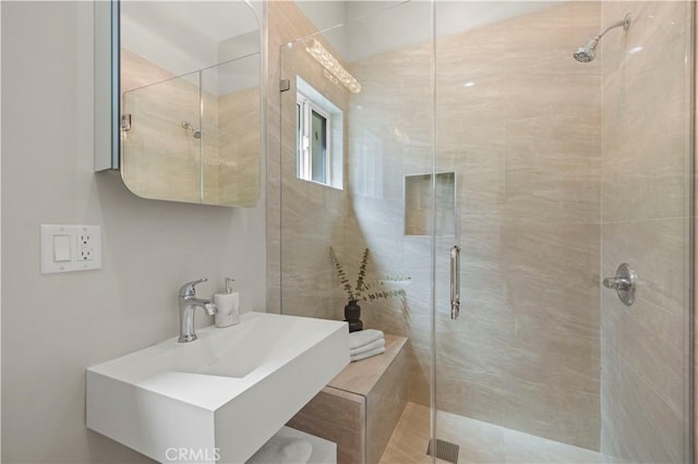 bathroom featuring a sink and a stall shower