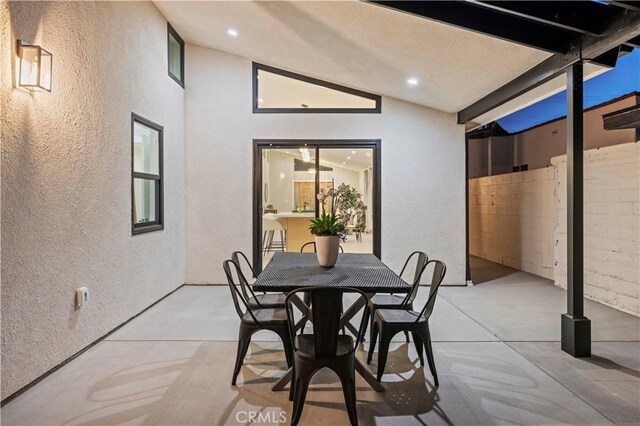 dining room with a textured wall, vaulted ceiling, and recessed lighting