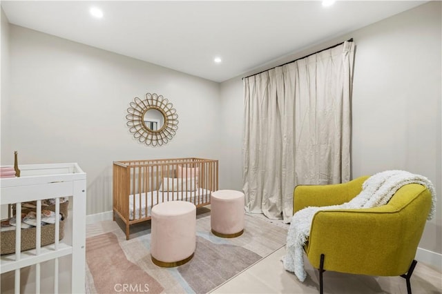bedroom with recessed lighting, a crib, and baseboards