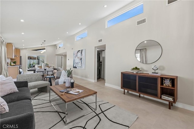 living room featuring recessed lighting, a high ceiling, baseboards, and light tile patterned floors
