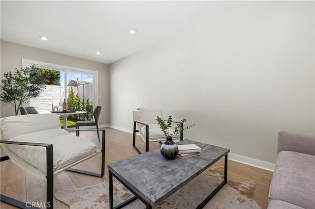 living room featuring baseboards, light wood-style floors, and recessed lighting