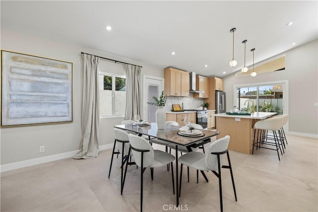 dining space with baseboards, lofted ceiling, and recessed lighting
