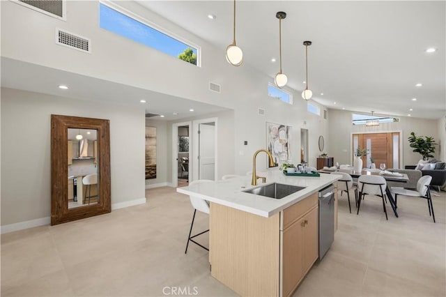 kitchen with a sink, dishwasher, open floor plan, recessed lighting, and a center island with sink