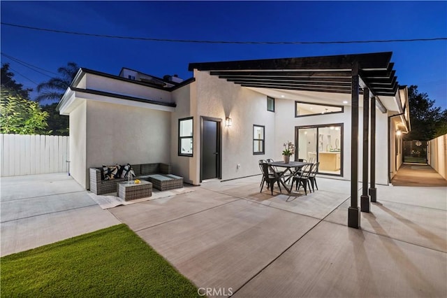 rear view of property with a patio area, fence, stucco siding, and an outdoor hangout area