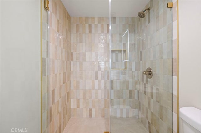 bathroom with tiled shower and toilet