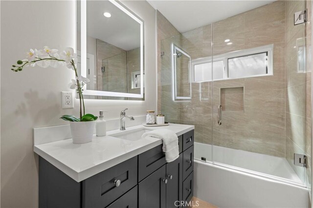 full bath with vanity and shower / bath combination with glass door