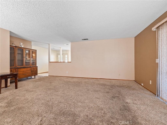 17949 Catalpa St, Hesperia, CA 92345 - unfurnished living room featuring a textured ceiling, light colored carpet, and baseboards