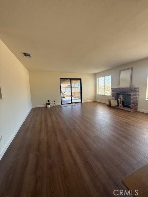 17949 Catalpa St, Hesperia, CA 92345 - unfurnished living room with dark wood finished floors and a brick fireplace