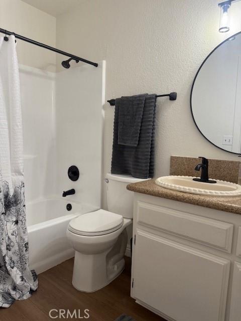 17949 Catalpa St, Hesperia, CA 92345 - bathroom featuring wood finished floors, vanity, and shower / bath combo with shower curtain