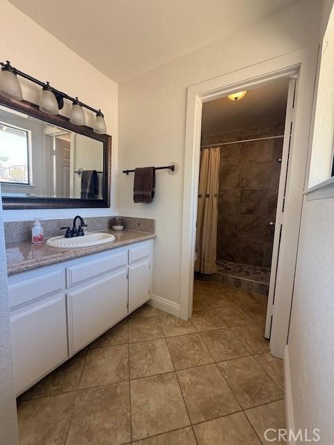 17949 Catalpa St, Hesperia, CA 92345 - bathroom featuring a tile shower, vanity, and tile patterned flooring