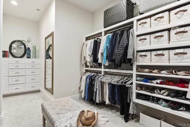 walk in closet featuring light carpet