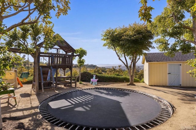 view of yard featuring a playground, a shed, and an outbuilding