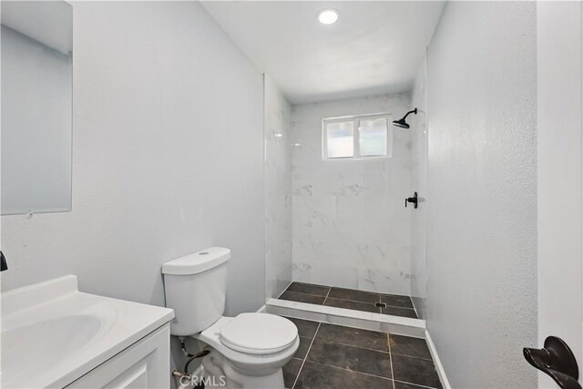43820 Beech Ave, Lancaster, CA 93534 - bathroom featuring toilet, a tile shower, vanity, and tile patterned floors