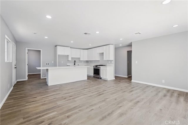 43820 Beech Ave, Lancaster, CA 93534 - unfurnished living room featuring baseboards, light wood-style flooring, recessed lighting, and a sink