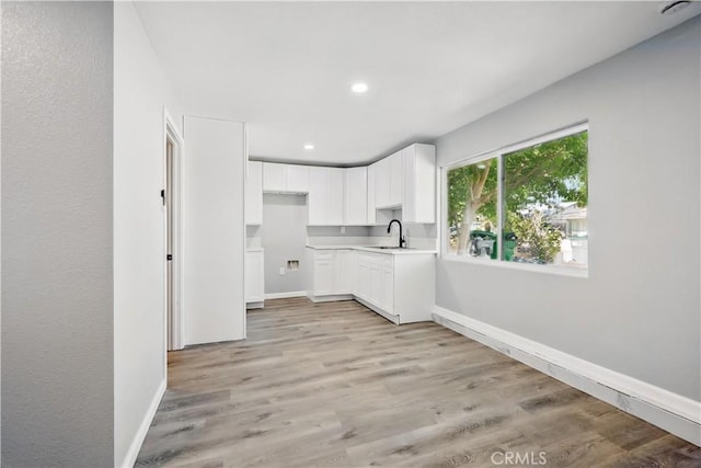 43820 Beech Ave, Lancaster, CA 93534 - kitchen with baseboards, white cabinetry, recessed lighting, light wood finished floors, and a sink