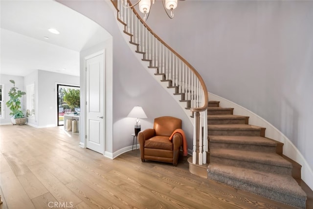 staircase featuring wood finished floors, baseboards, and recessed lighting