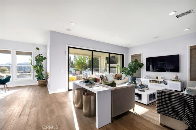 living area featuring light wood finished floors, baseboards, and recessed lighting