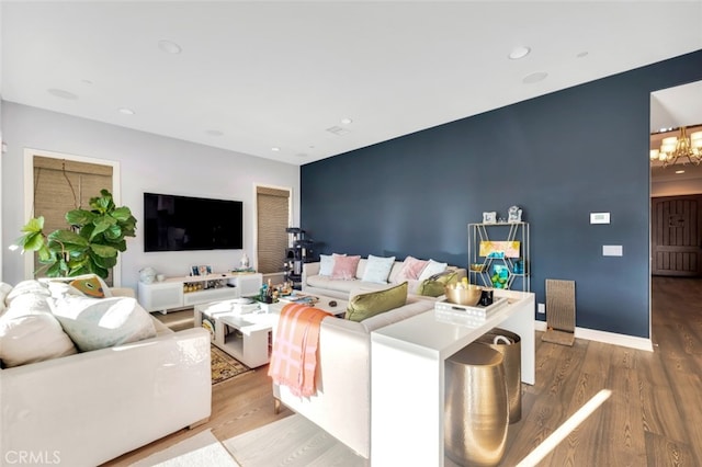 living area with wood finished floors, a chandelier, recessed lighting, and baseboards