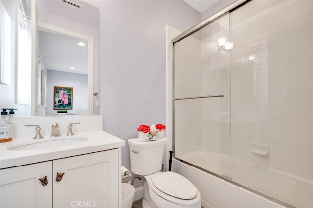 bathroom with vanity, toilet, bath / shower combo with glass door, and recessed lighting